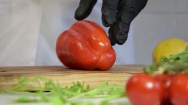 Aşçı kırmızı biberi doğrama tahtasındaki bıçakla ikiye böler, ağır çekimde..