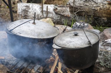 Kapaklı metal kazanlar ısıtılır ve ormanda bir ateşte tütsülenir, yemek pişirmek için turist yemekleri yapılır..