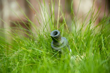 Metal çim musluğu çimenlerin üzerine kurulmuş, yan görüş, seçici odak, yakın çekim.