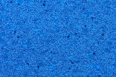 Dokulu küçük parçacıklar, çakıl taşları ve parıltılarla soyut mavi arkaplan.