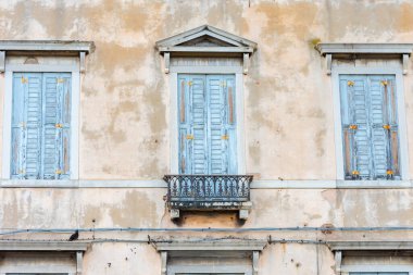 Tarihi merkezdeki harap olmuş bir binanın pencerelerine kapalı panjurlar.