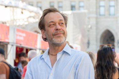 Kalabalığın arkasında kendinden emin orta yaşlı bir adamın portresi