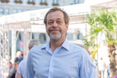 Bulanık şehir geçmişinde sakallı, 50-55 yaşındaki bir adamın duygusal portresi.