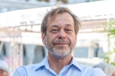 50-55 yaşlarındaki yaşlı bir adamın sokak portresi. Arka planı bulanık, yakın plan sakallı.