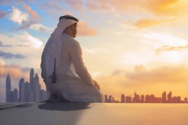 Arap adam geleneksel Emirlikleri giysileri BAE Çöl açık Dubai manzarası içinde dua ile.