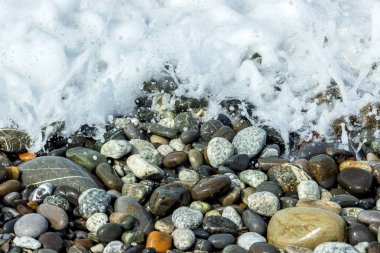 Renkli taşlar ve sahilde dalgalar Soyut doku.