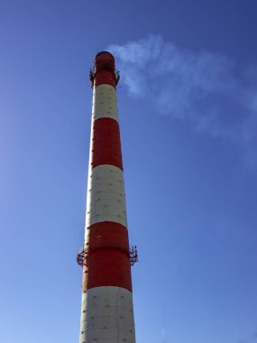 Bir Fabrika baca mavi gökyüzü karşı gelen duman. Dikey görünüm.