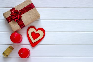 Ahşap beyaz arka plan kırmızı kalpler, hediyeler ve mum. Sevgililer günü kavramı. Üstten görünüm.