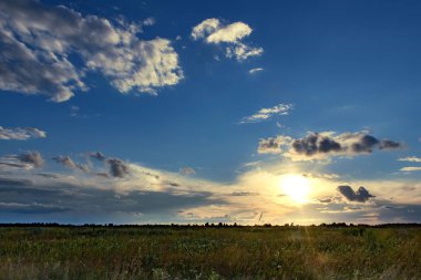 Sunset over fields with clouds during late summer
