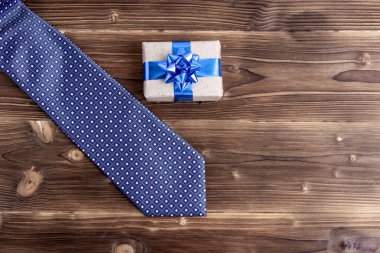 Kravat ve gözetiminde ahşap arka plan ile mutlu Babalar günü. Selamlar ve hediyeler