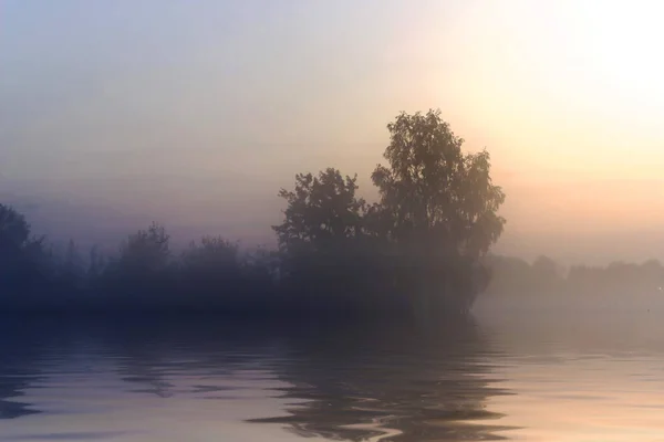 Rural early morning sunrise with lake, fog and russians landscape.