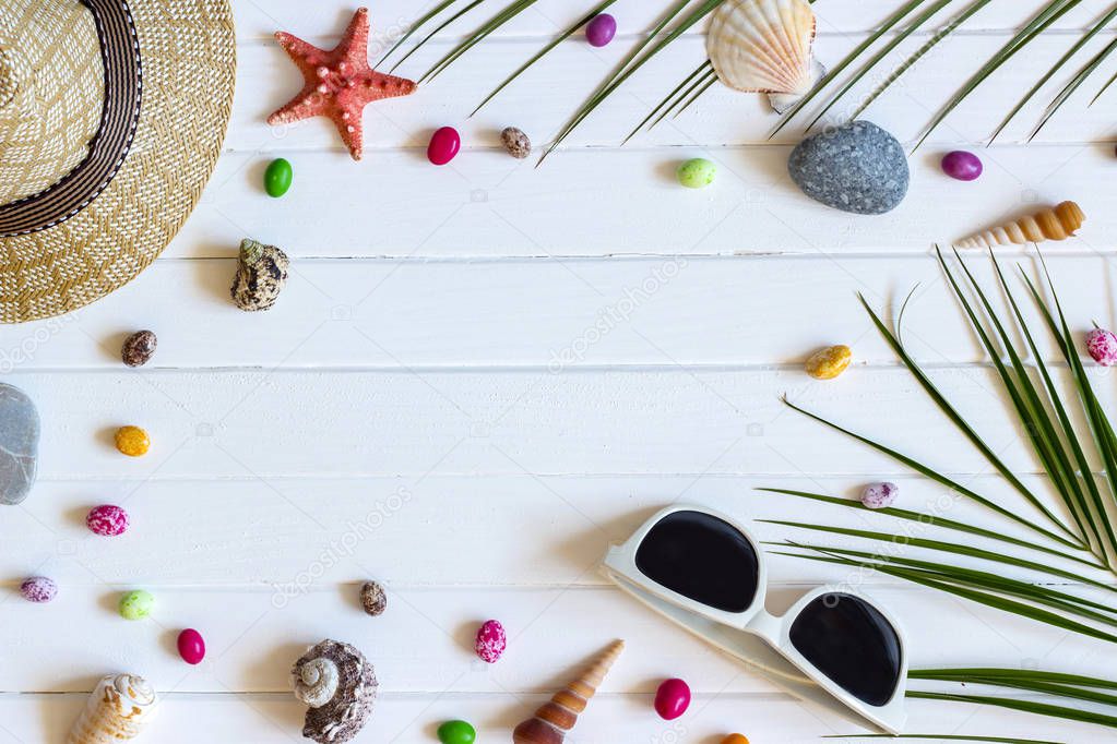 Traveler accessories, tropical palm leaf branches on white wooden background with empty space for text. Travel vacation concept. Summer background. Road frame set. Flat lay, top view.