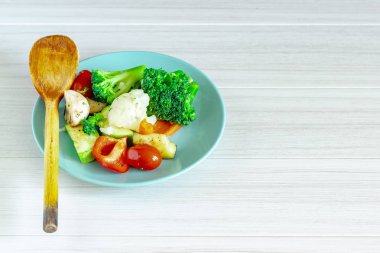 Beyaz arka planda mavi tabakta taze sebzeler. Sağlıklı gıda.