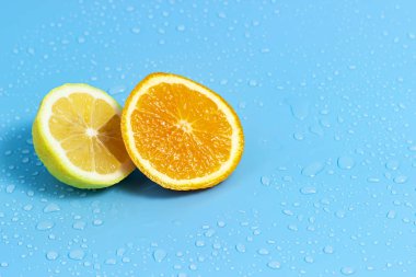 Su damlaları ile mavi bir arka plan üzerinde portakal ve limon Dilimleri. Yaz serin su portakal dilimleri.