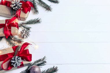 Noel arka plan konsepti. Ladin dalları, çam kozalağı, beyaz ahşap masa arka plan üzerinde kırmızı çilek ile Noel hediye kutusu üst görünümü.