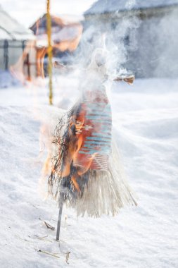 Rusya'da Maslenitsa. Küçük bebek Maslenitsa bir sembolüdür, korkuluk kış sonu ve baharın gelişinin bir sembolü olarak yanıyor.