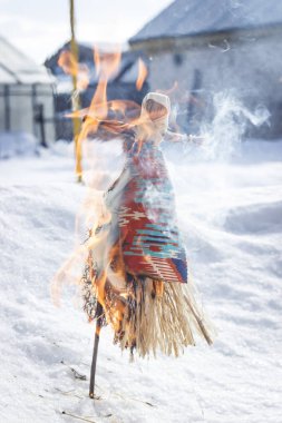 Rusya'da Maslenitsa. Küçük bebek Maslenitsa bir sembolüdür, korkuluk kış sonu ve baharın gelişinin bir sembolü olarak yanıyor.