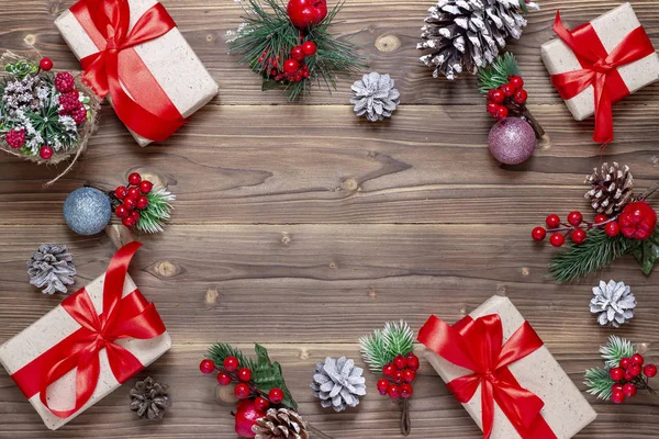 Buon Natale e felice anno nuovo sfondo. Scatole con regali, giocattoli e coni sul vecchio sfondo di legno. Vista dall'alto . — Foto Stock