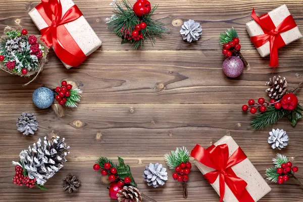 Buon Natale e felice anno nuovo sfondo. Scatole con regali, giocattoli e coni sul vecchio sfondo di legno. Vista dall'alto . — Foto Stock