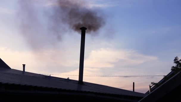 Metal pipe on roof of house with black smoke coming from it. — Stock Video