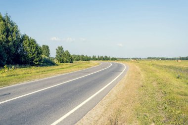 Asfalt yol virajın etrafındaki mesafeye doğru gidiyor.