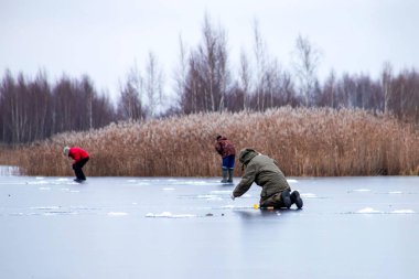 Balıkçılar buzun altında olta balığı avlarken yakalandı.