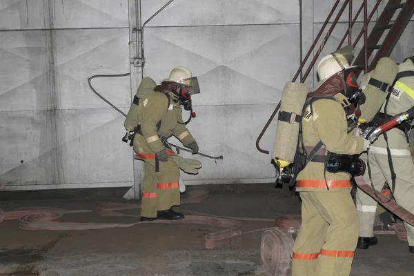 消防士が工場の場合火災の抑制を満たすため — ストック写真