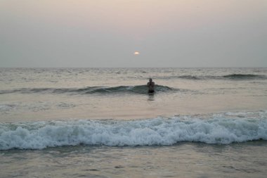 Hint Okyanusu yıkanan bir günbatımı üzerinde 