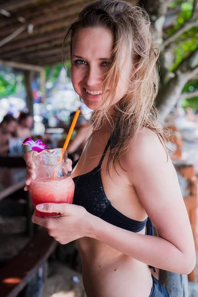 Sport fitness vrouw drinken van gezonde roze detox SAP, fruit smoothie op het strand zomer buitenleven. Fitness gezonde levensstijl. — Stockfoto