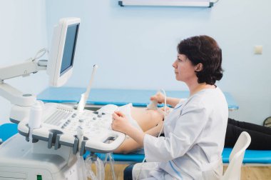Ultrason tarayıcı kullanarak mutlu olgun kadın doktor. Echography makine