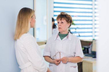 Olgun doktor hastane ofis tanı konusunda meslektaşı ile konuşurken.