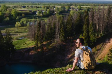 Adam içinde yansıtan gökyüzü göl yukarıda Uçurumdaki ayakta