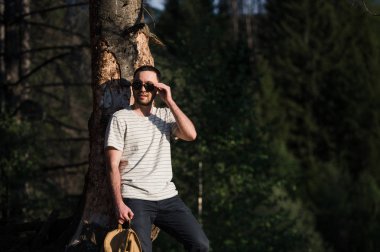 bir ormanda güneş gözlüğü takıyor bir hipster adam portresi Güzel Sanatlar.