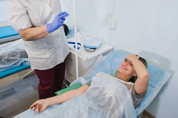 Professionelle Krankenschwester, die einer Frau, die im Krankenhaus auf dem Operationstisch liegt, eine Spritze verabreicht, um ein Konzept für eine Operation unter Narkose vorzubereiten. — Stockfoto