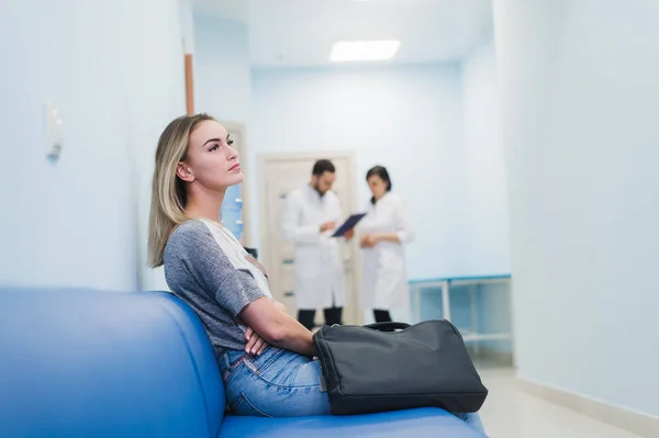 Woman patient waiting at hospital Doctors Waiting Room.