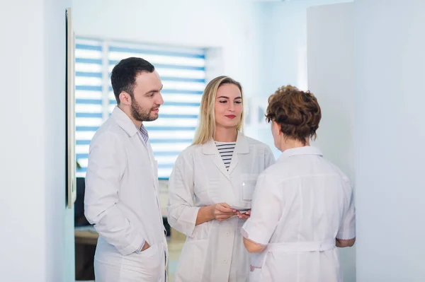 Grupo de médicos de alto nivel y enfermeras jóvenes que examinan el informe médico del paciente. Equipo de médicos trabajando juntos en el archivo de pacientes en el hospital. Personal médico que analiza y trabaja en la clínica — Foto de Stock