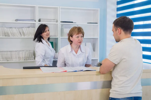 Paciente masculino con médico y enfermera en recepción en el hospital — Foto de Stock