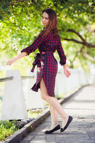 Jolie jeune femme montre sa jambe tout en marchant dans le parc — Photo