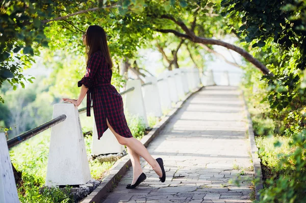 Jeunes jolies femmes avec de longs cheveux venteux en robe violette debout à l'escalier — Photo