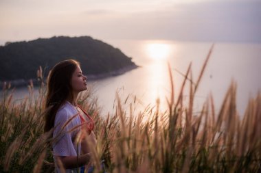 Bir yaz gün batımı beyaz buğday alanda kadın