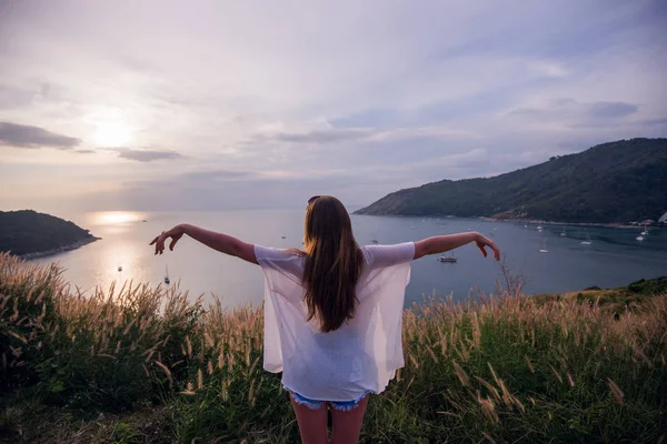 Glückliche Frau am Sonnenuntergang in der Natur im Sommer mit offenen Händen — Stockfoto