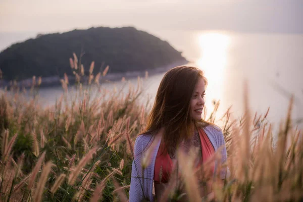 Frau in einem Weizenfeld bei einem sommerlichen Sonnenuntergang — Stockfoto