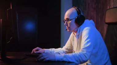 Kızgın genç adam kulaklık ile evde oyun oynarken ve akarsu pc bilgisayar çığlık playthrough veya anlatım video oynayalım