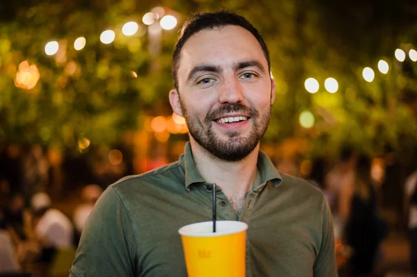 Красивий бородатий європейських пити людина популярними або пиво Відкритий кафе на вулиці вночі партії в парку — стокове фото