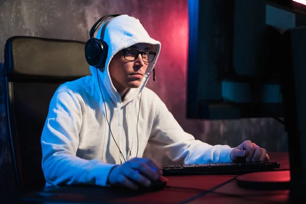 Ανδρικό με κουκούλα gamer παίζει online παιχνίδι στον υπολογιστή pc — Φωτογραφία Αρχείου