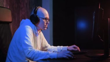 Kızgın genç adam kulaklık ile evde oyun oynarken ve akarsu pc bilgisayar çığlık playthrough veya anlatım video oynayalım