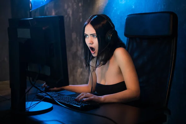 Chica gamer. Emocionado enojado conmocionado joven mujer jugando videojuegos en una computadora PC gritando mirando en una pantalla —  Fotos de Stock