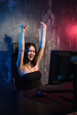 Mutlu neşeli sevimli seksi oyun kız el hareketi kazanmak ve saf duygu. Ev video oyun oynarken yalnız bir pc bilgisayar üzerinde oturan