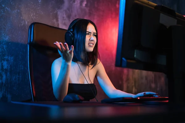 Chica gamer. Emocionado enojado conmocionado joven mujer jugando videojuegos en una computadora PC gritando mirando en una pantalla —  Fotos de Stock