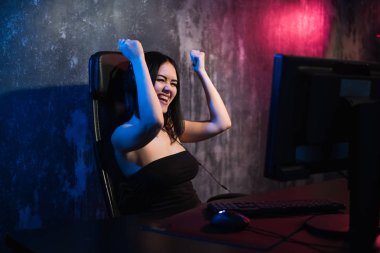 Mutlu neşeli sevimli seksi oyun kız el hareketi kazanmak ve saf duygu. Ev video oyun oynarken yalnız bir pc bilgisayar üzerinde oturan